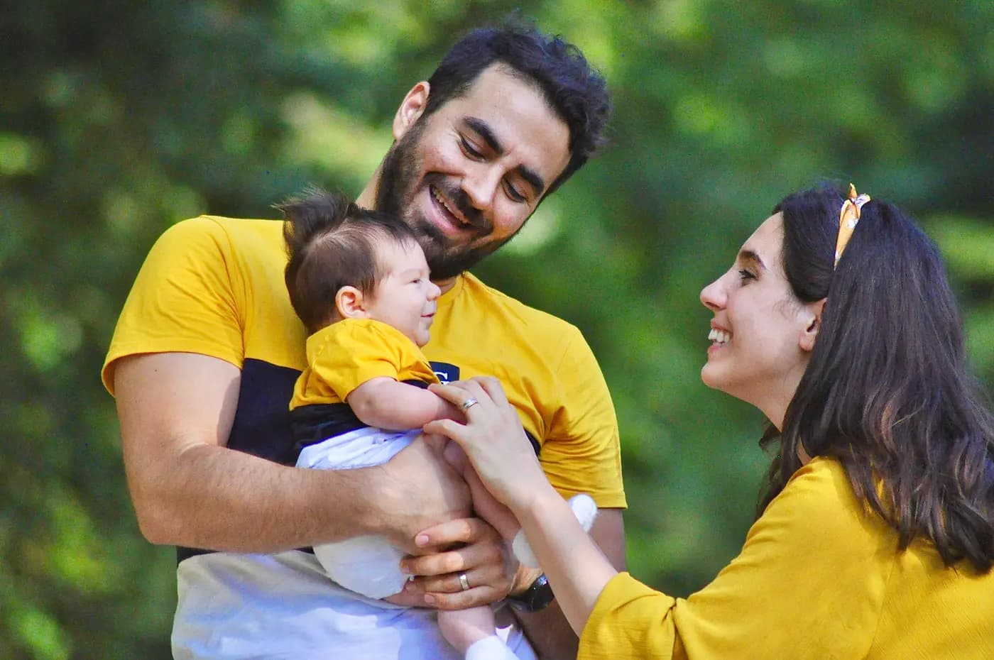 Familia sonriendo junto a un bebé, en un momento de cercanía y cuidado